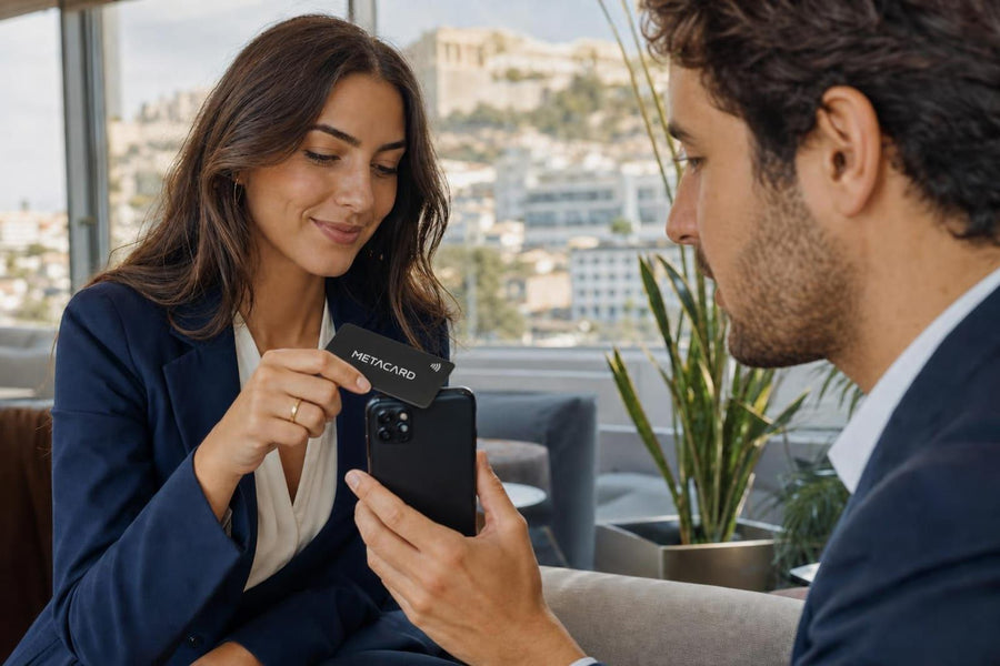 Επαγγελματίας ακουμπά NFC επαγγελματική κάρτα METACARD στο iPhone συναδέλφου σε γραφείο στην Αθήνα