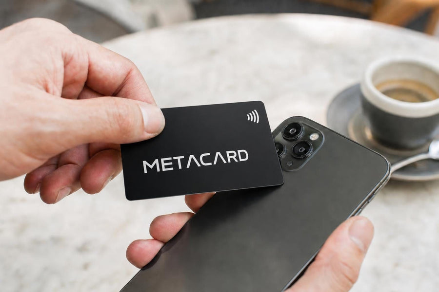 Χέρι ακουμπά NFC επαγγελματική κάρτα METACARD στο πίσω μέρος iPhone